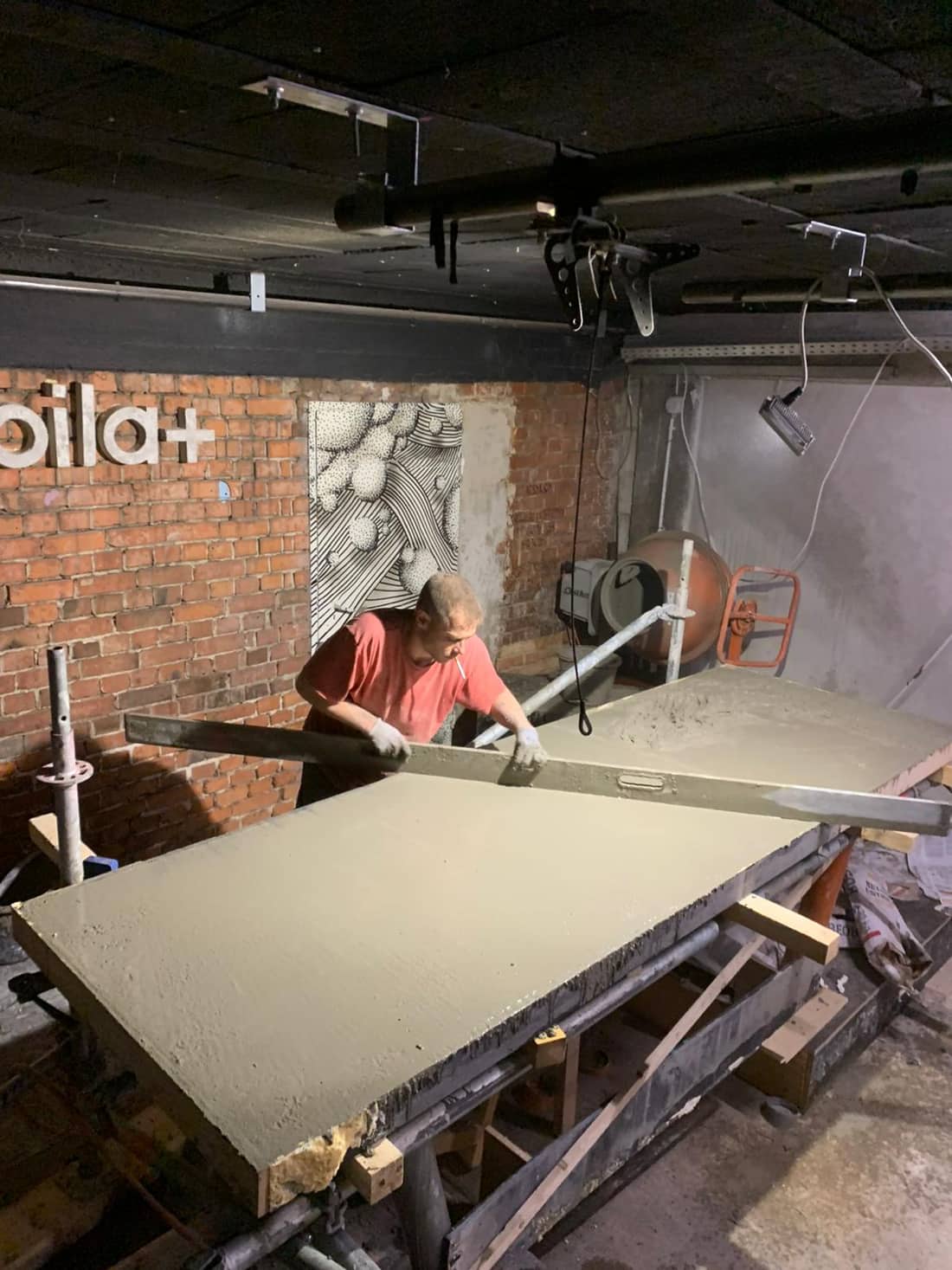 BMS-Handwerker glättet eine frisch gegossene Betontheke beim Umbau des Mobilat in Heilbronn